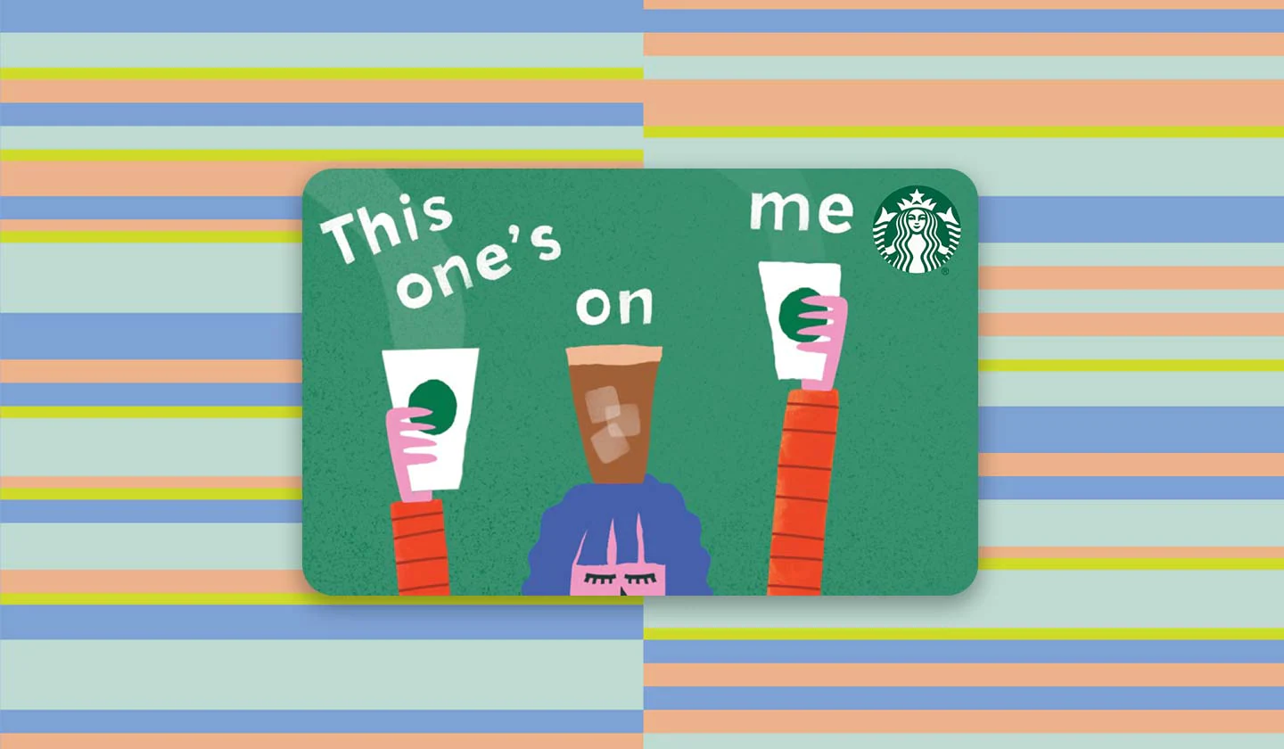 A gift card with a person peeking from the bottom, hands raised and holding Starbucks cups. It says, “This one’s on me.”